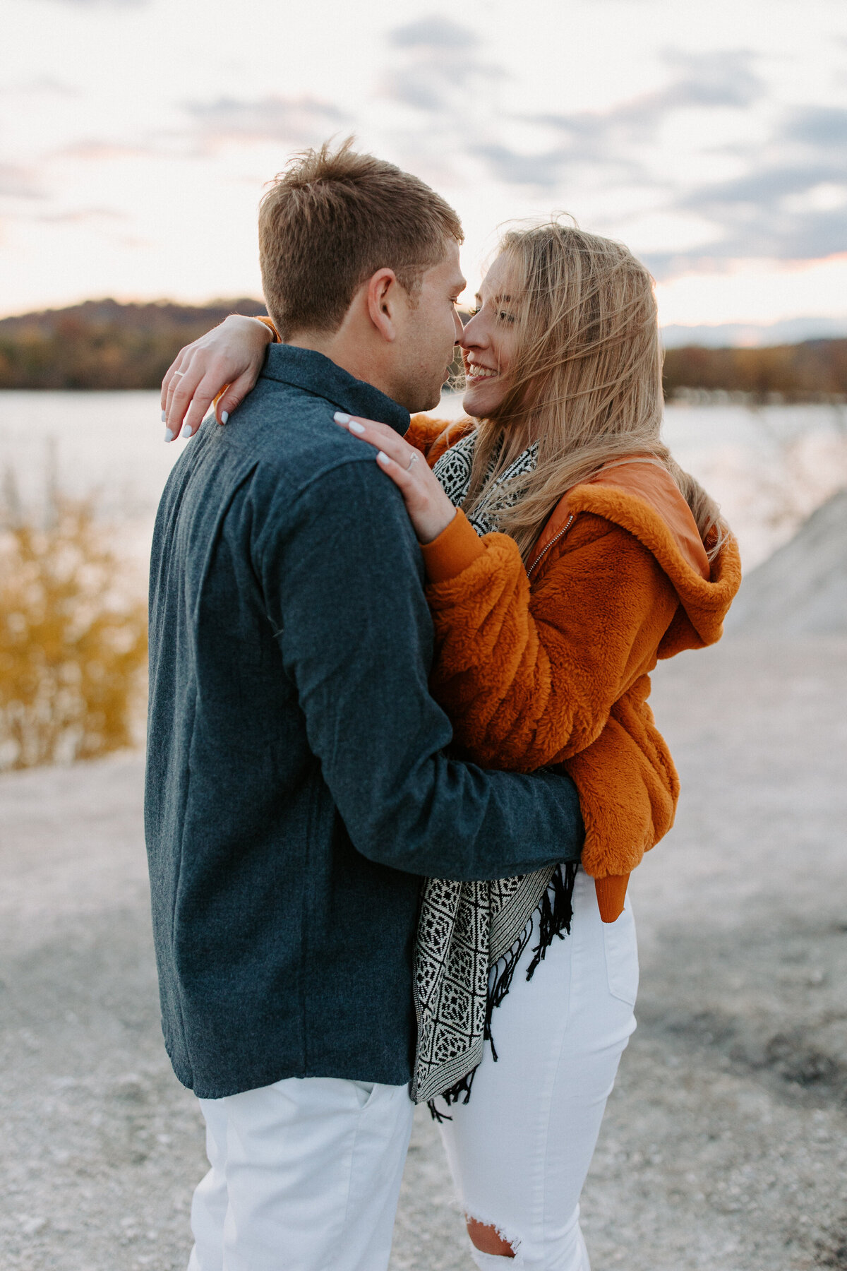 couple with their arms around each other as they are about to kiss