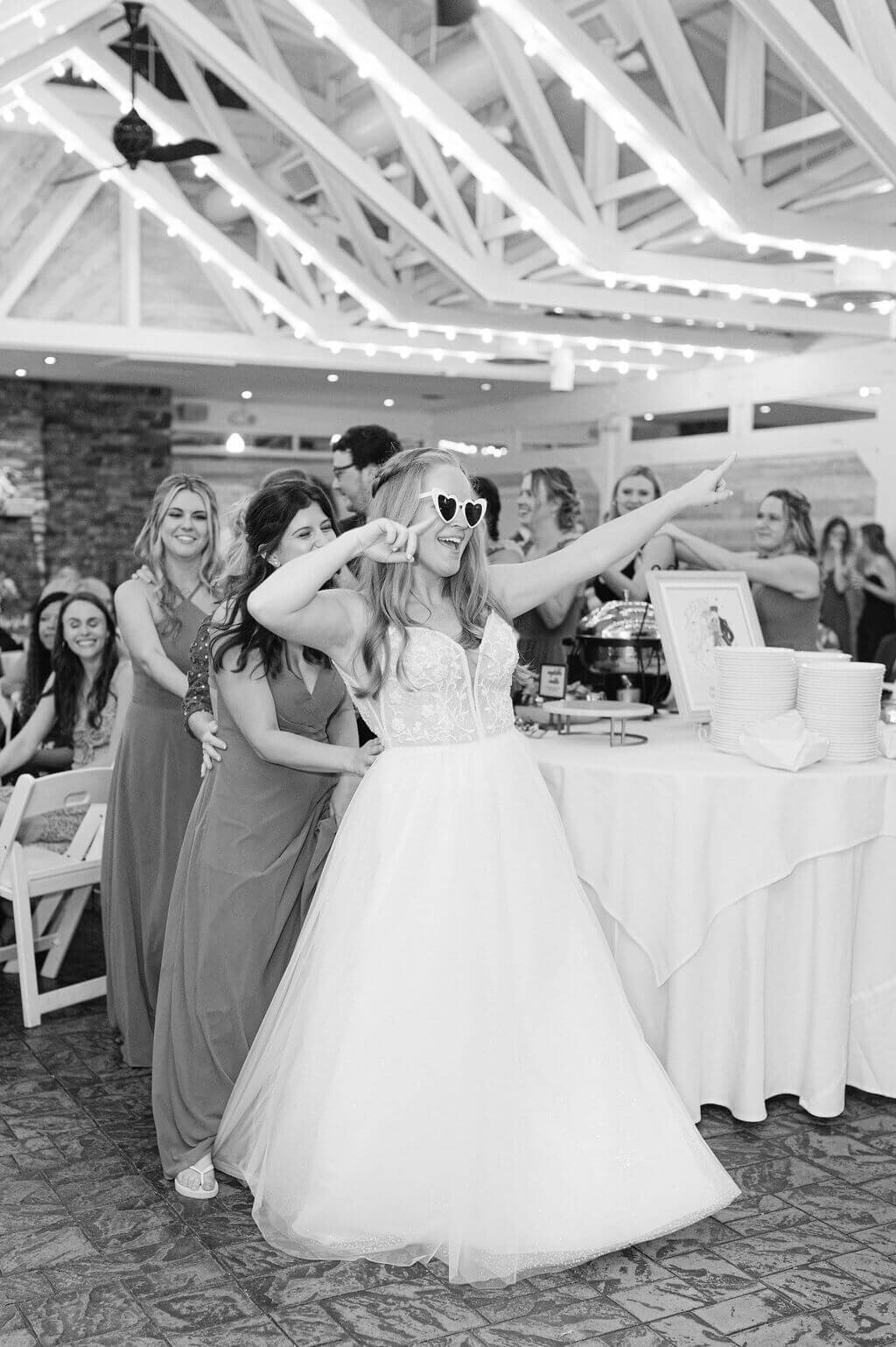 Bride wearing sunglasses and dancing at her wedding reception