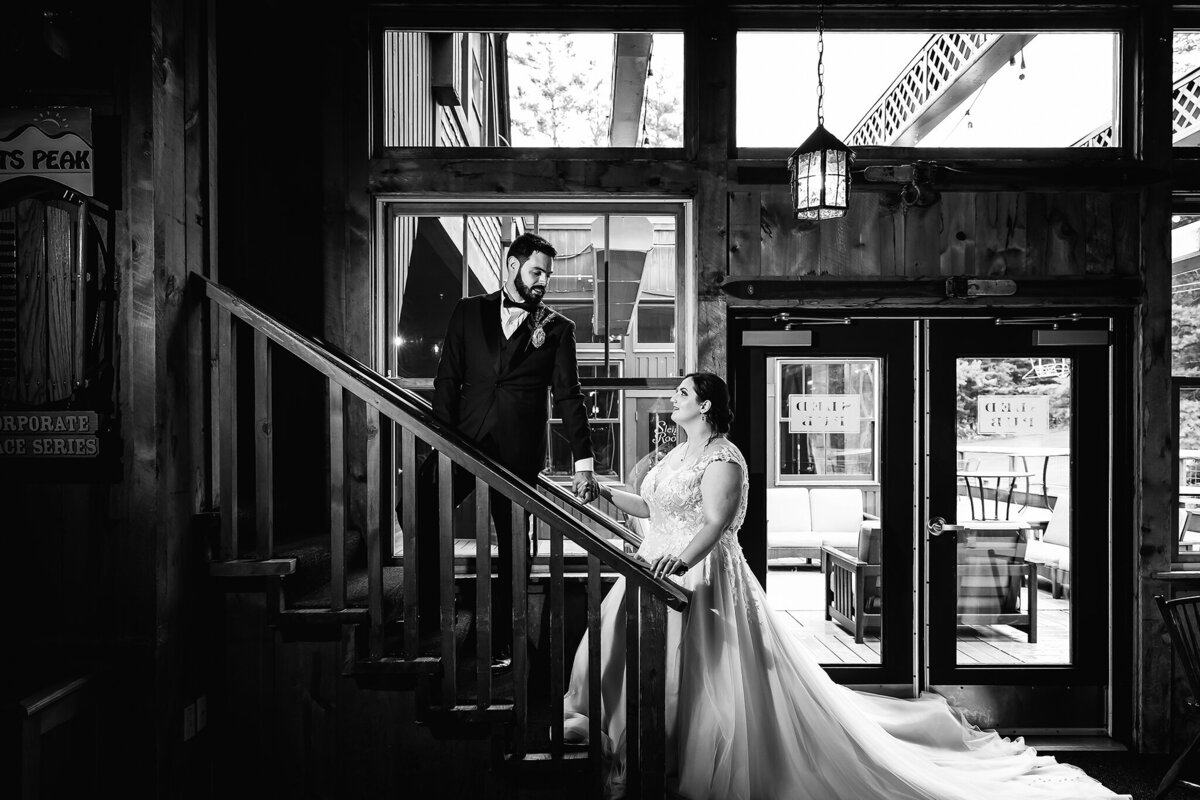 groom leading bride up stairs at wedding in Pats Peak Lodge in Henniker NH wedding
