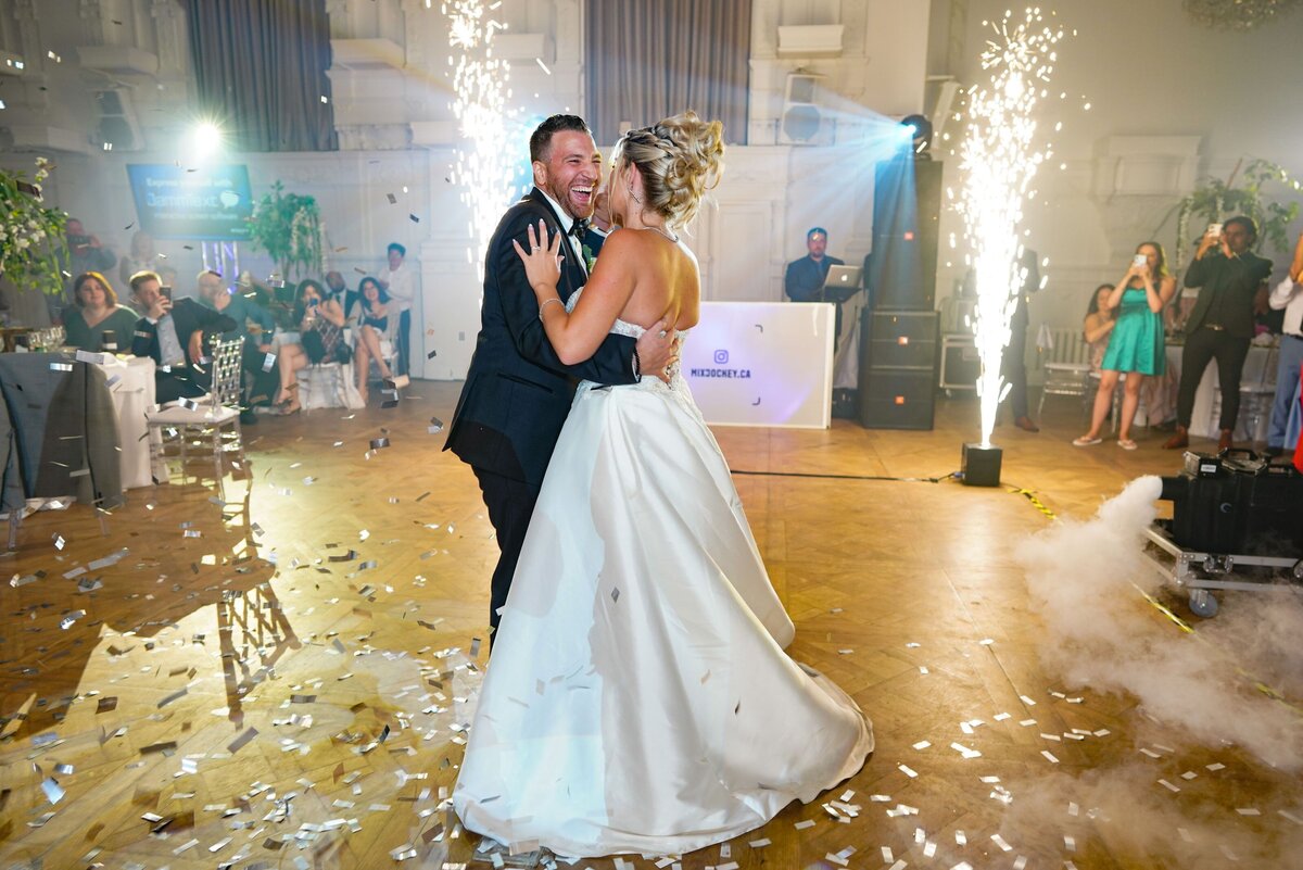 The bride and groom share their first dance as a married couple, illuminated by a spectacular display of fireworks, creating a magical and celebratory atmosphere.