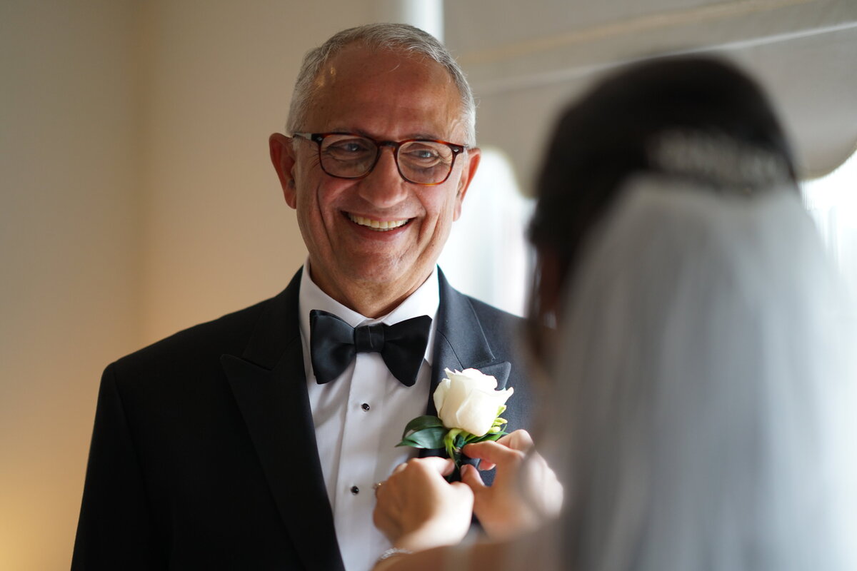 A touching moment between a bride and her father, capturing their emotional connection and joy. This image highlights the special bond and heartfelt moments shared during the bridal portrait session, reflecting the warmth and significance of family on the wedding day.