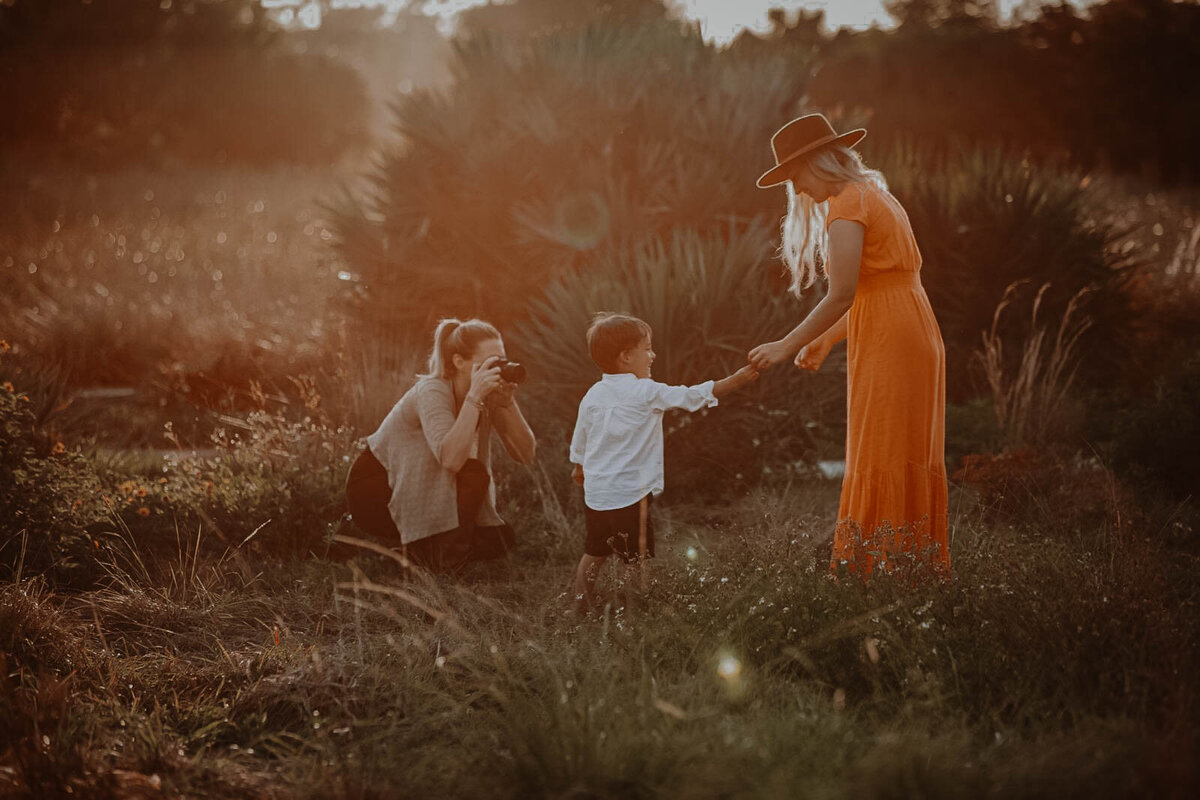 Photographer taking photo of a women and her son in a field