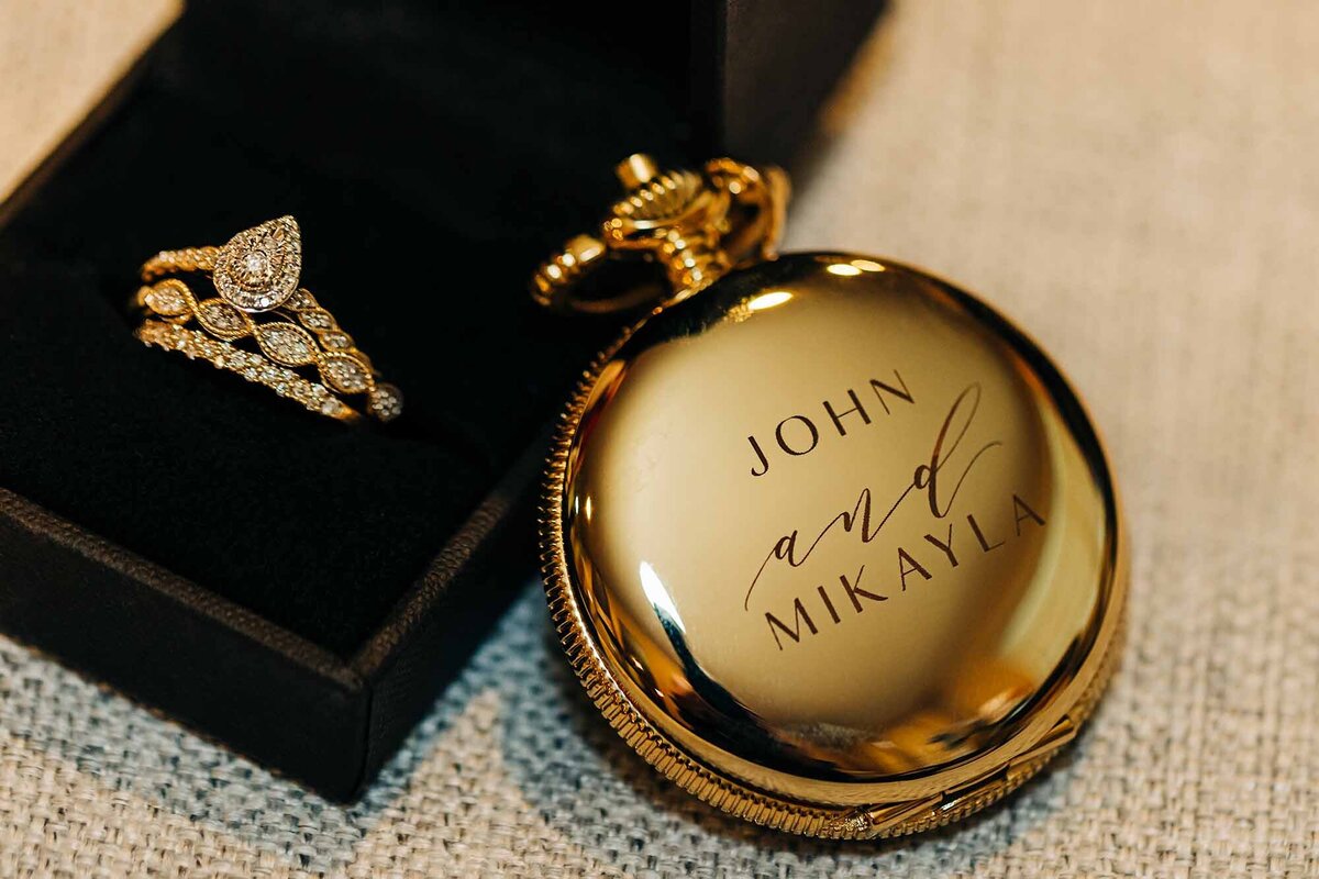 Close up of wedding rings and engraved gold pocket watch