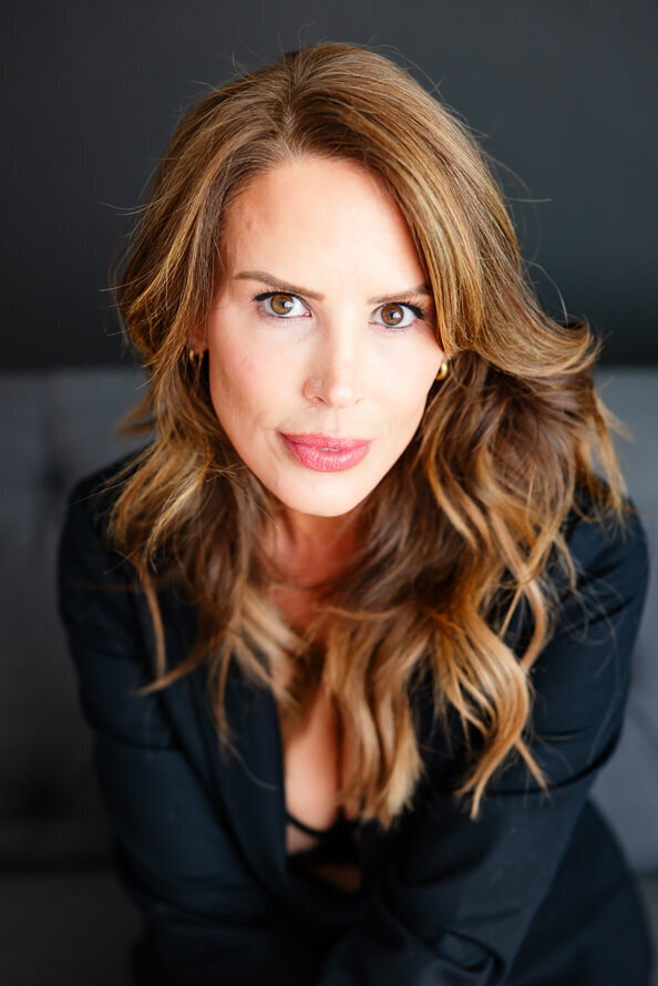 Close up of owman with long brown hair on a gray couch.