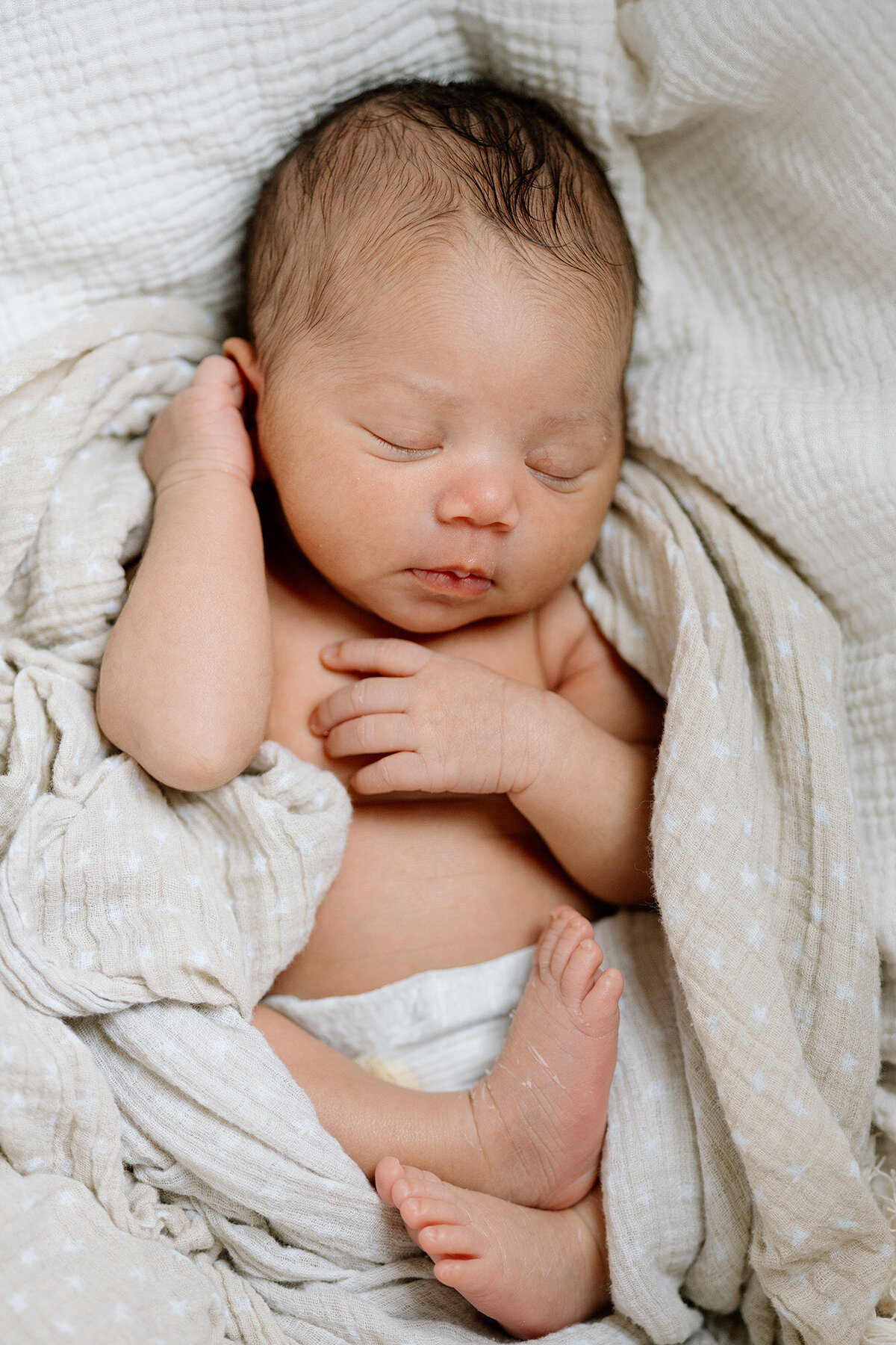 Newborn sleeping peacefully swaddled in soft neutral tones