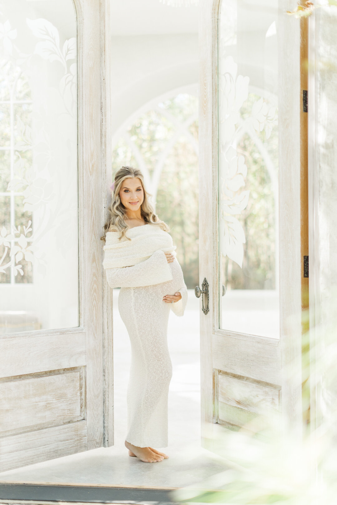 mom stands in doorway at the oak atelier studio in conroe, texas