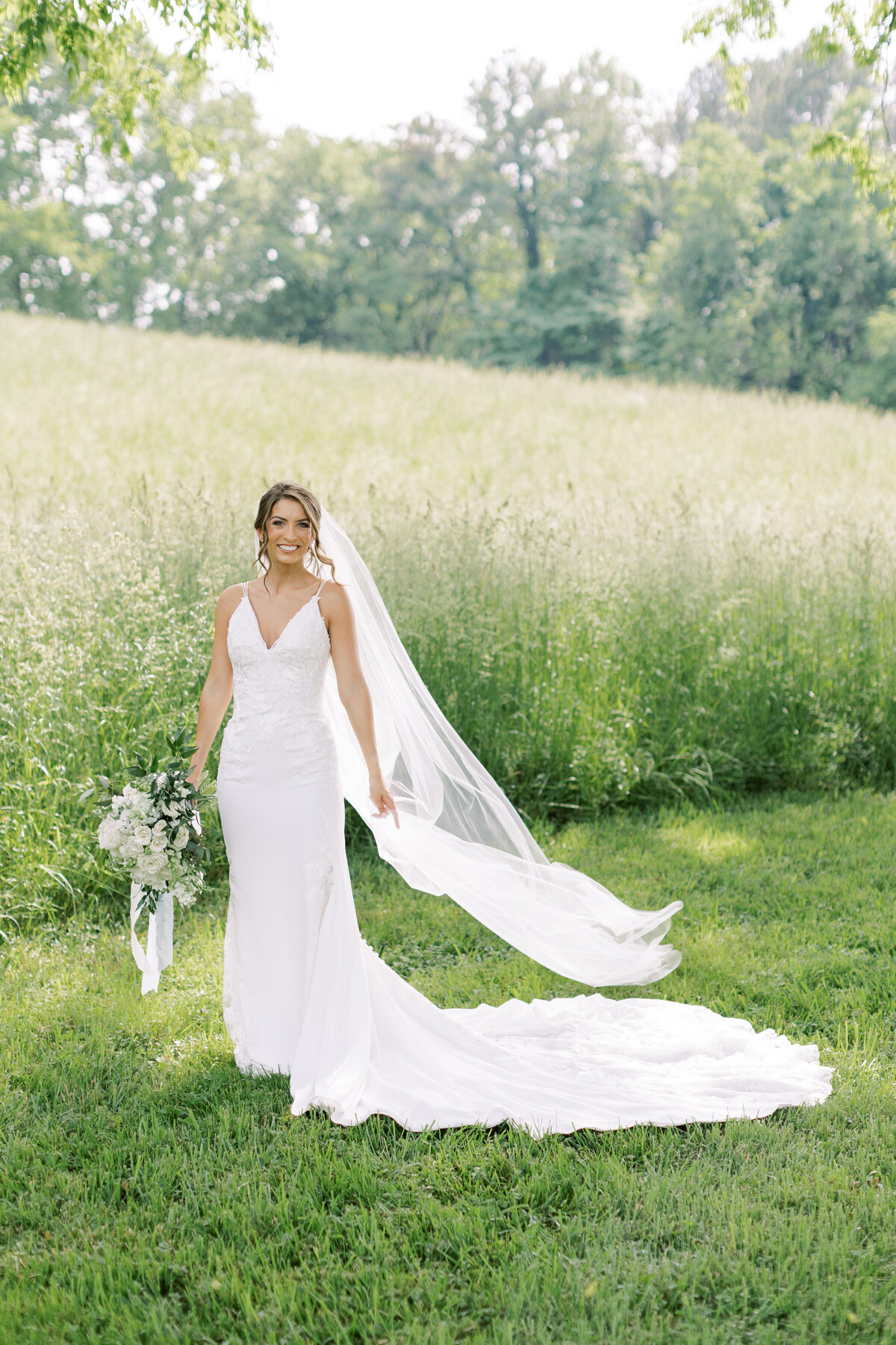 bride-with-flowing-veil-in-field