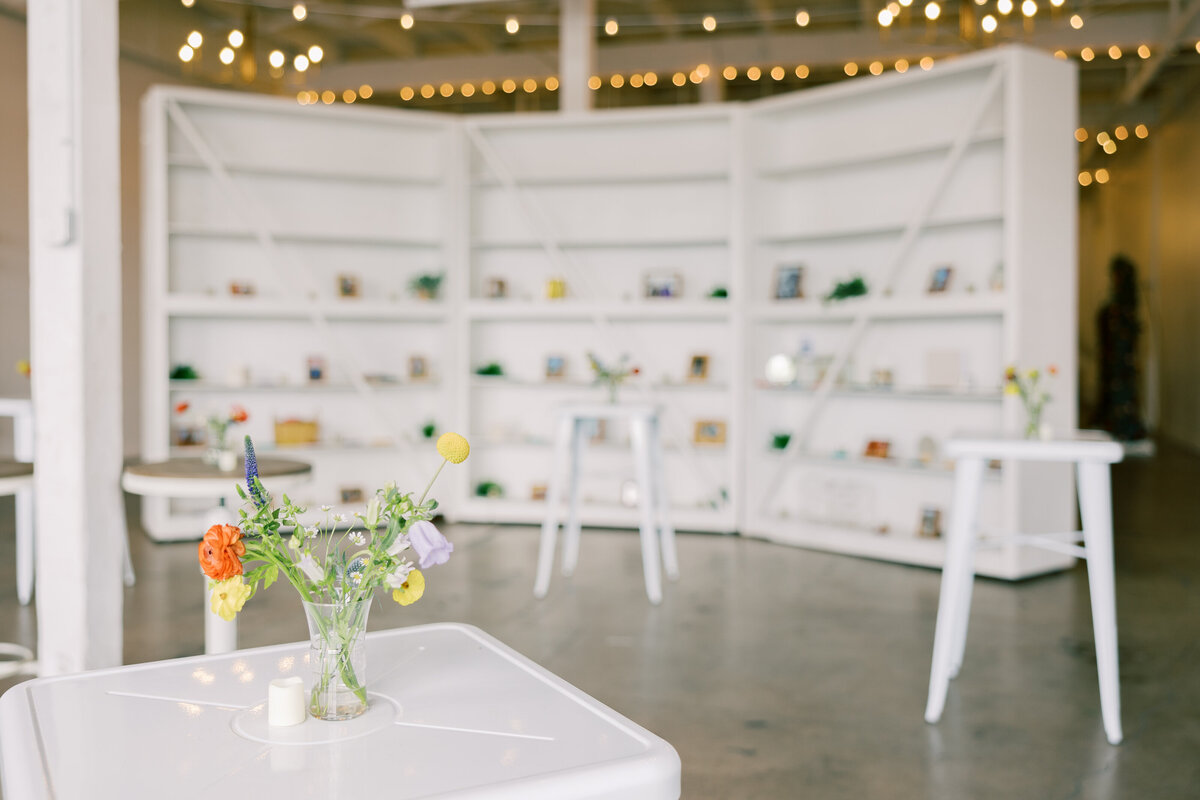 Reception tables decorated with colorful floral centerpieces by Crimson & Clover and string lights at Fetewell wedding in Baltimore.