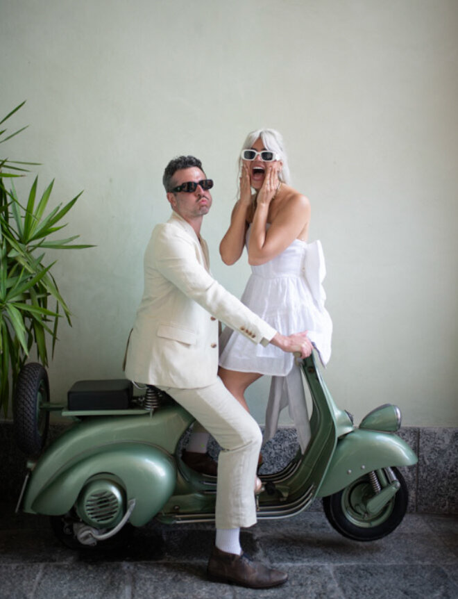 The couple laughing together on a vintage scooter, beautifully captured in their Lake Como engagement session by Christine Grace Photography