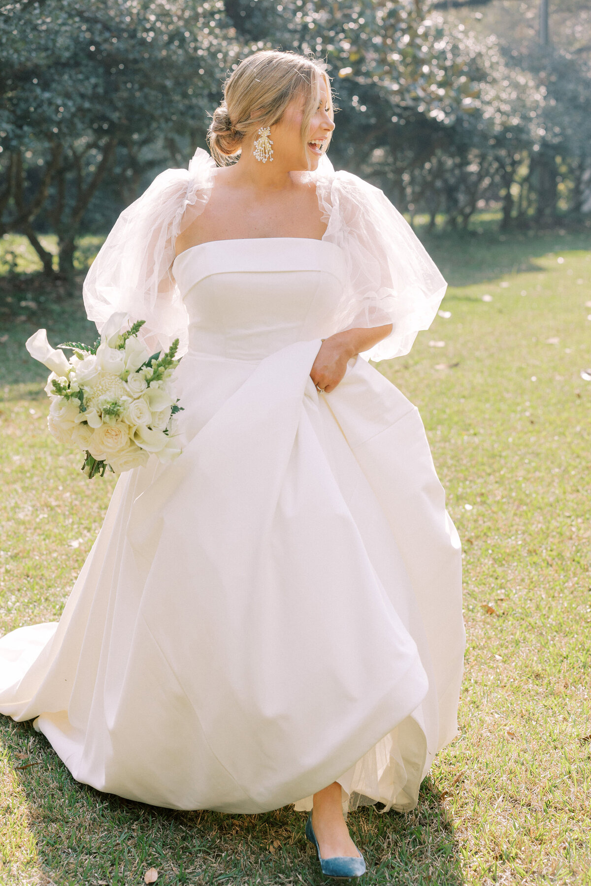 Stunning bride walks while carrying her bridal bouquet
