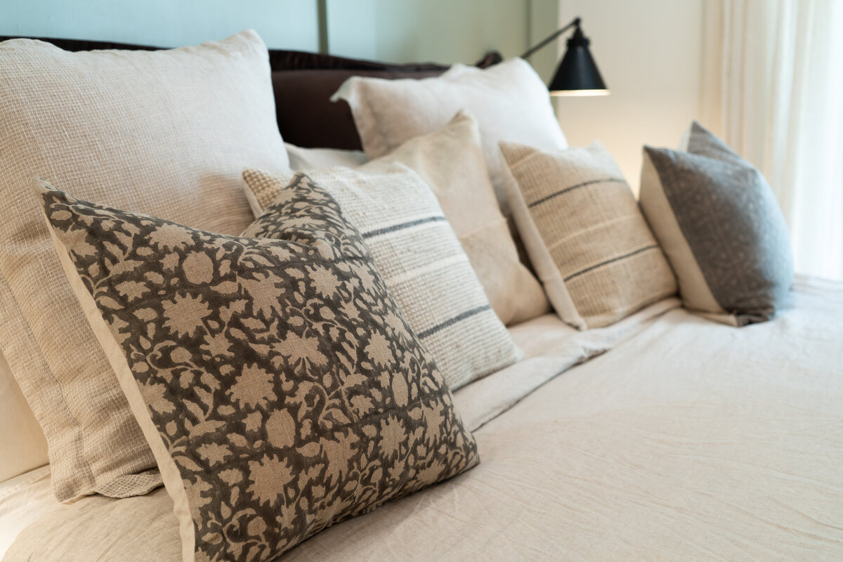 luxury bedroom with white dresser white sitting chiar and bed with blue blanket