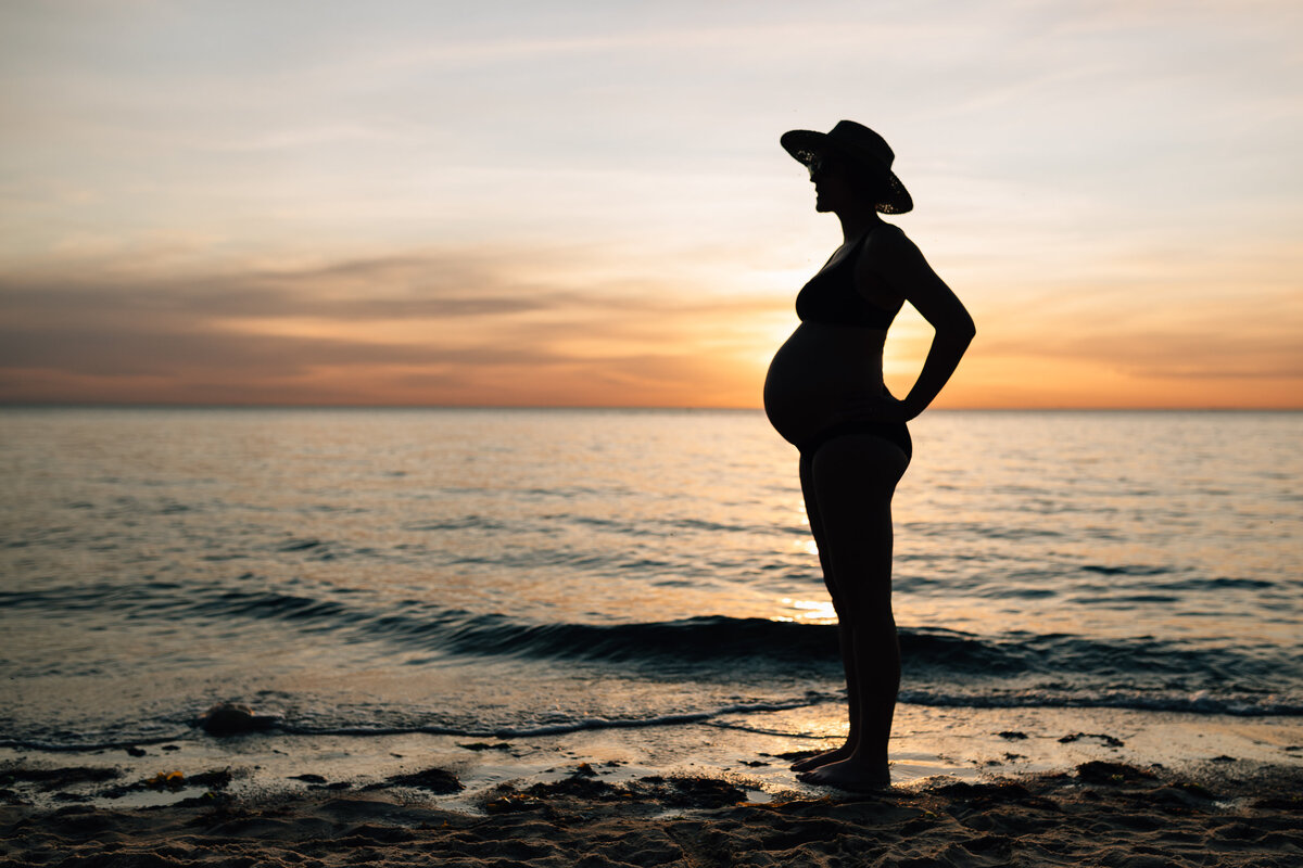 silhouette of pregnant woman at beach against sunset,  maternity photography Melbourne by And So I Don't Forget Photography