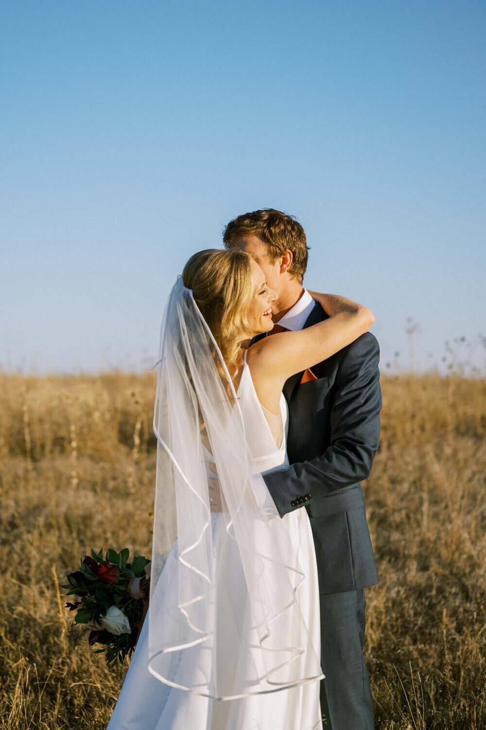 couple-embracing-in-sunshine-filled-field