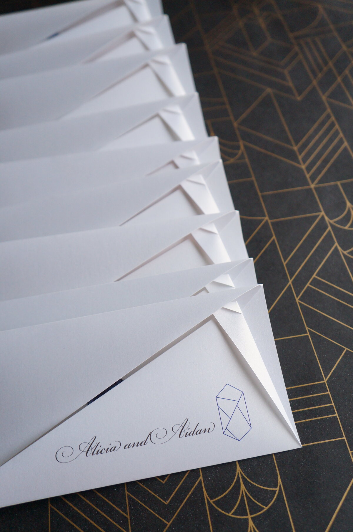 Origami wedding invitations with script font and graphic gemstone icon