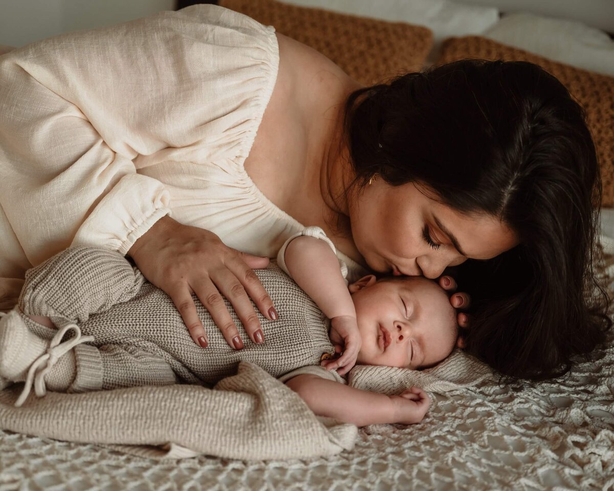 moeder met slapende baby op bed newbornshoot Eline Hemelt Photography