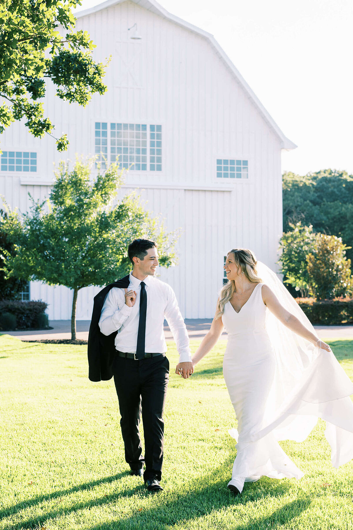 Newly married couple walks on lawn at The White Sparrow in Texas