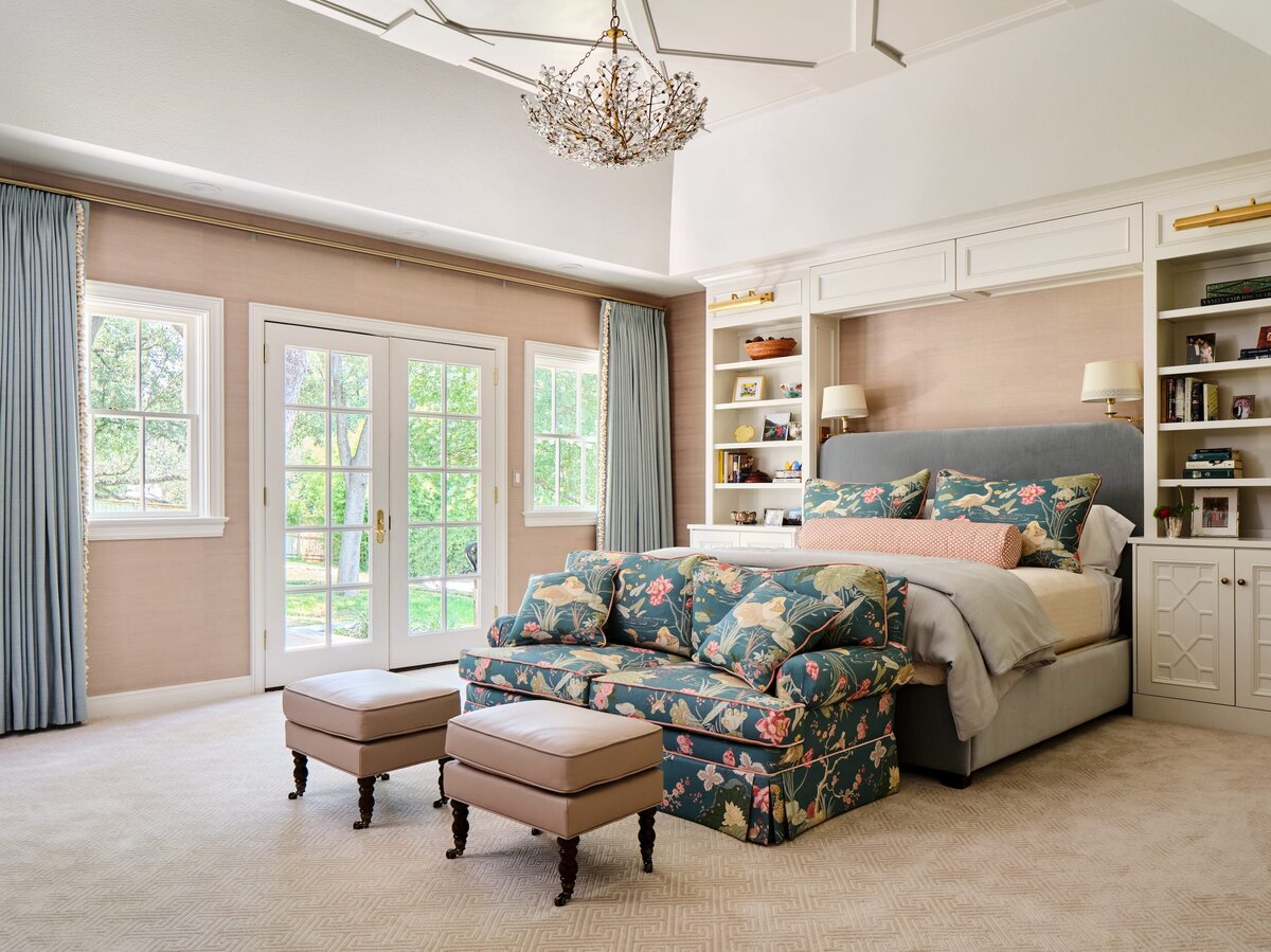 the keeping room interiors morningside bedroom with light pink walls and colorful sofa at end of bed