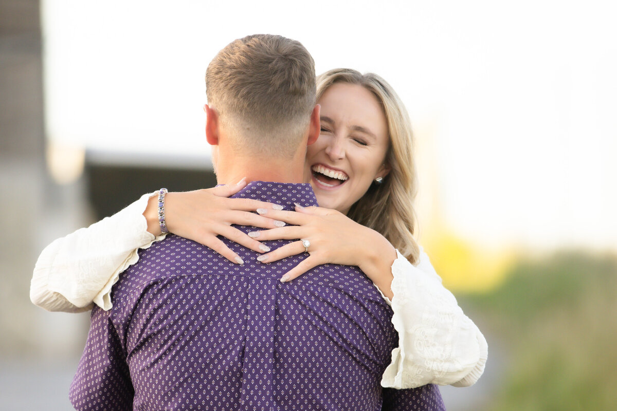 girl hugging fiance and laughing with wedding ring