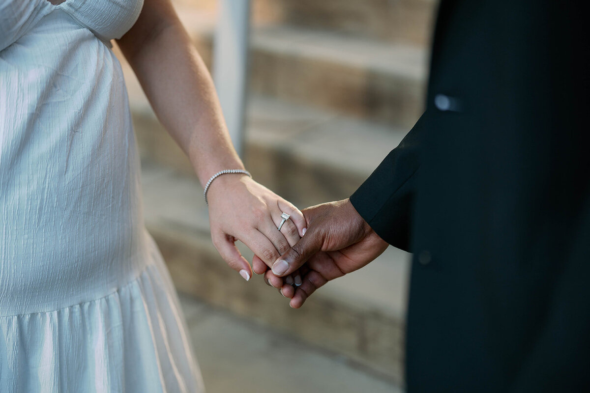 Close-up of couple holding hands showing engagement ring during Kalamazoo engagement session.