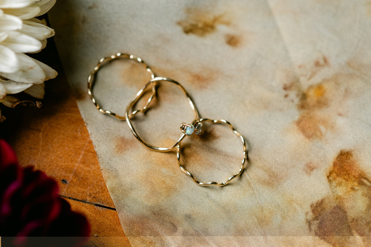 Close up of wedding rings with sage background