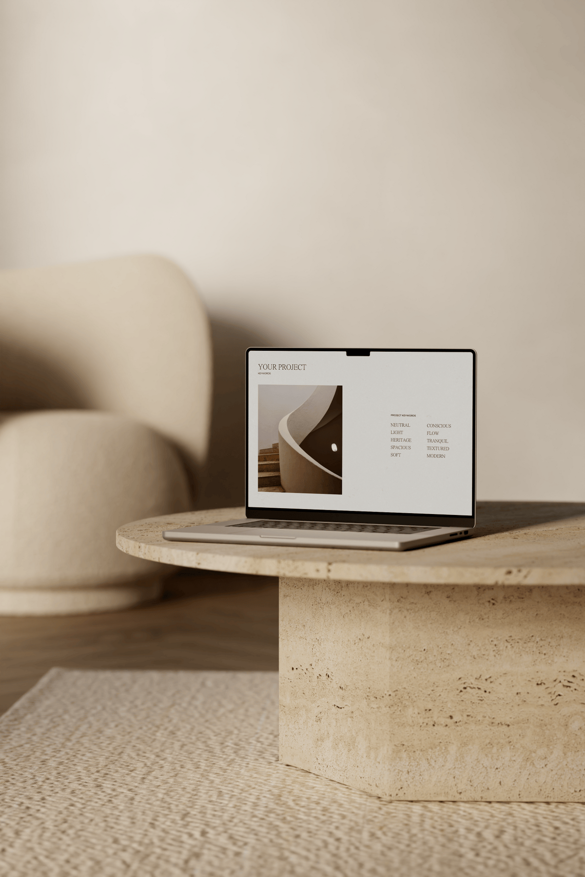 A laptop sits atop a travertine coffee table on a cream rug, with a cream bouclé occasional chair in the background. The screen displays the keywords section of a Styling Concept created by Elizabeth Davis.