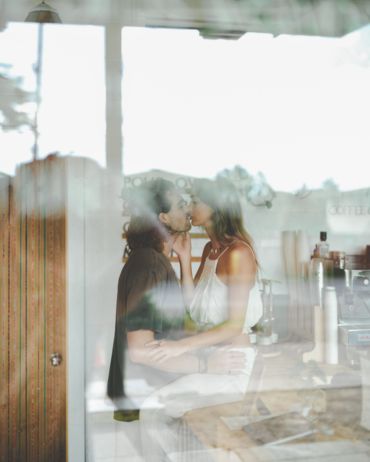 Looking through a window at couple kissing