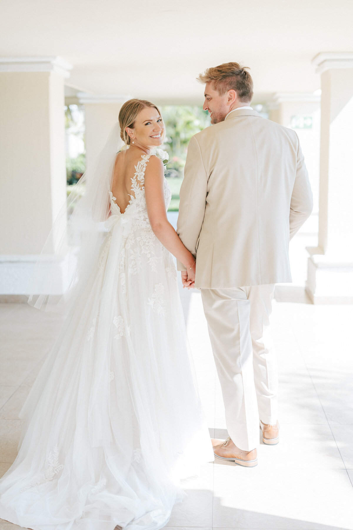 Cancun bride and groom hold hands and smile, captured by a Philadelphia-based wedding photographer.