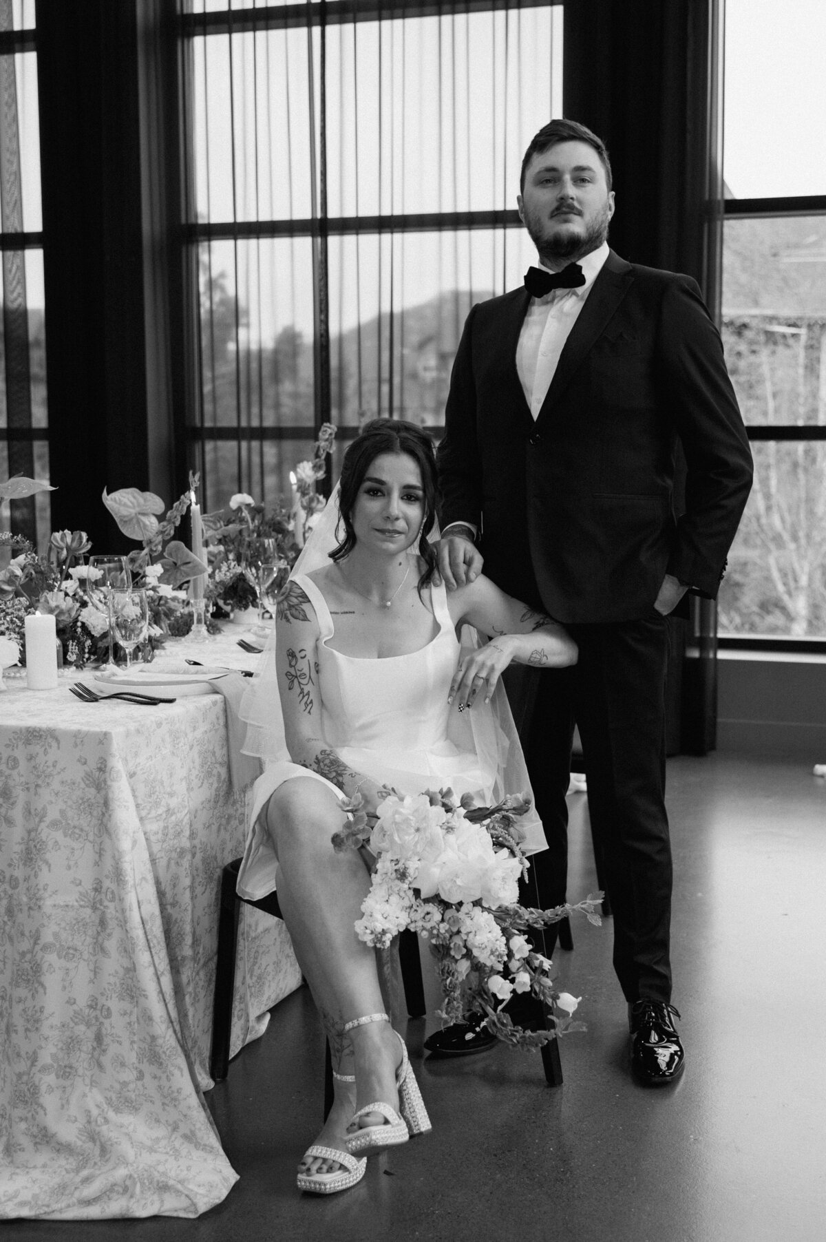 Stylish seated wedding portrait of bride and groom in natural light-filled venue in Banff.