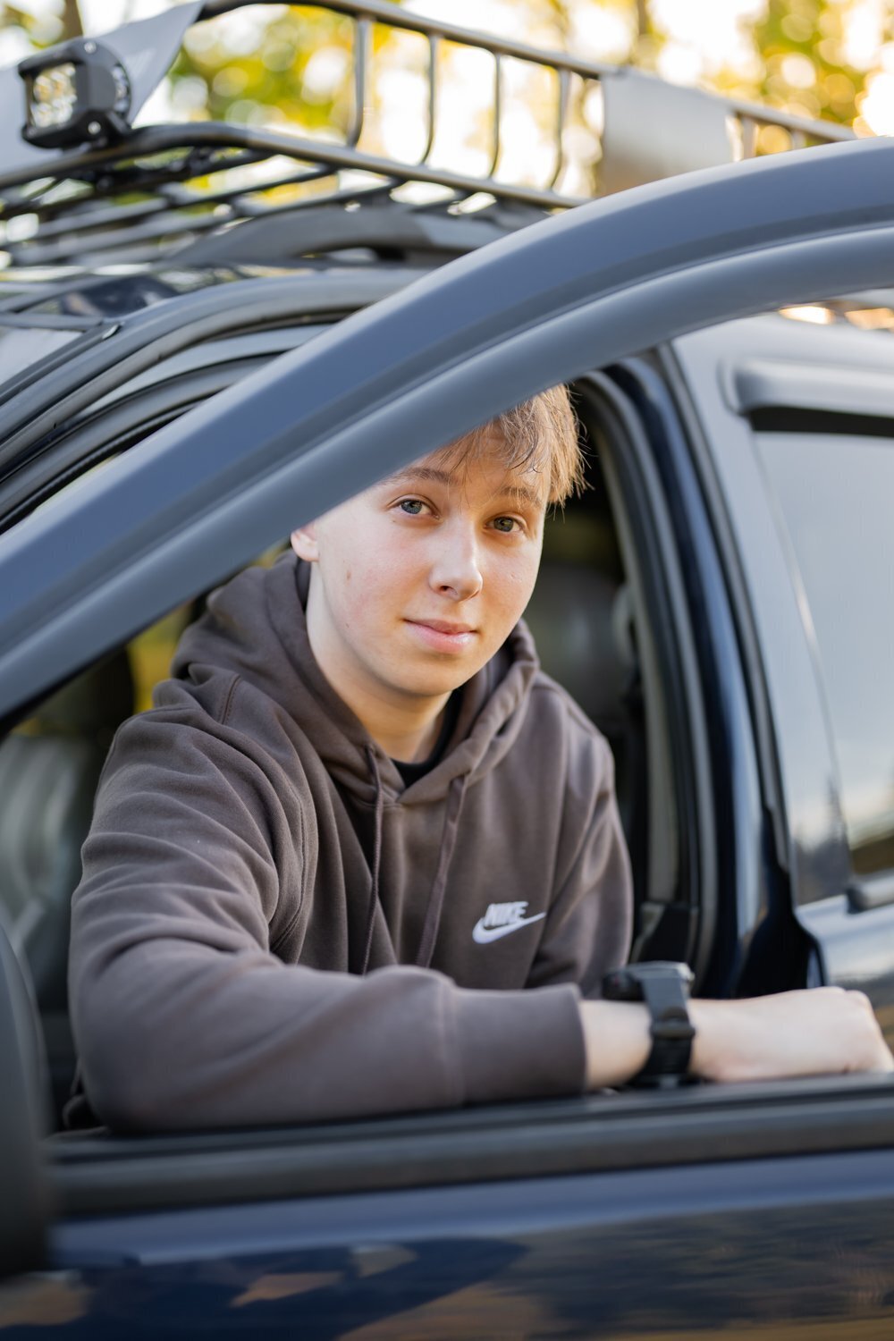 senior guy posing seated in car