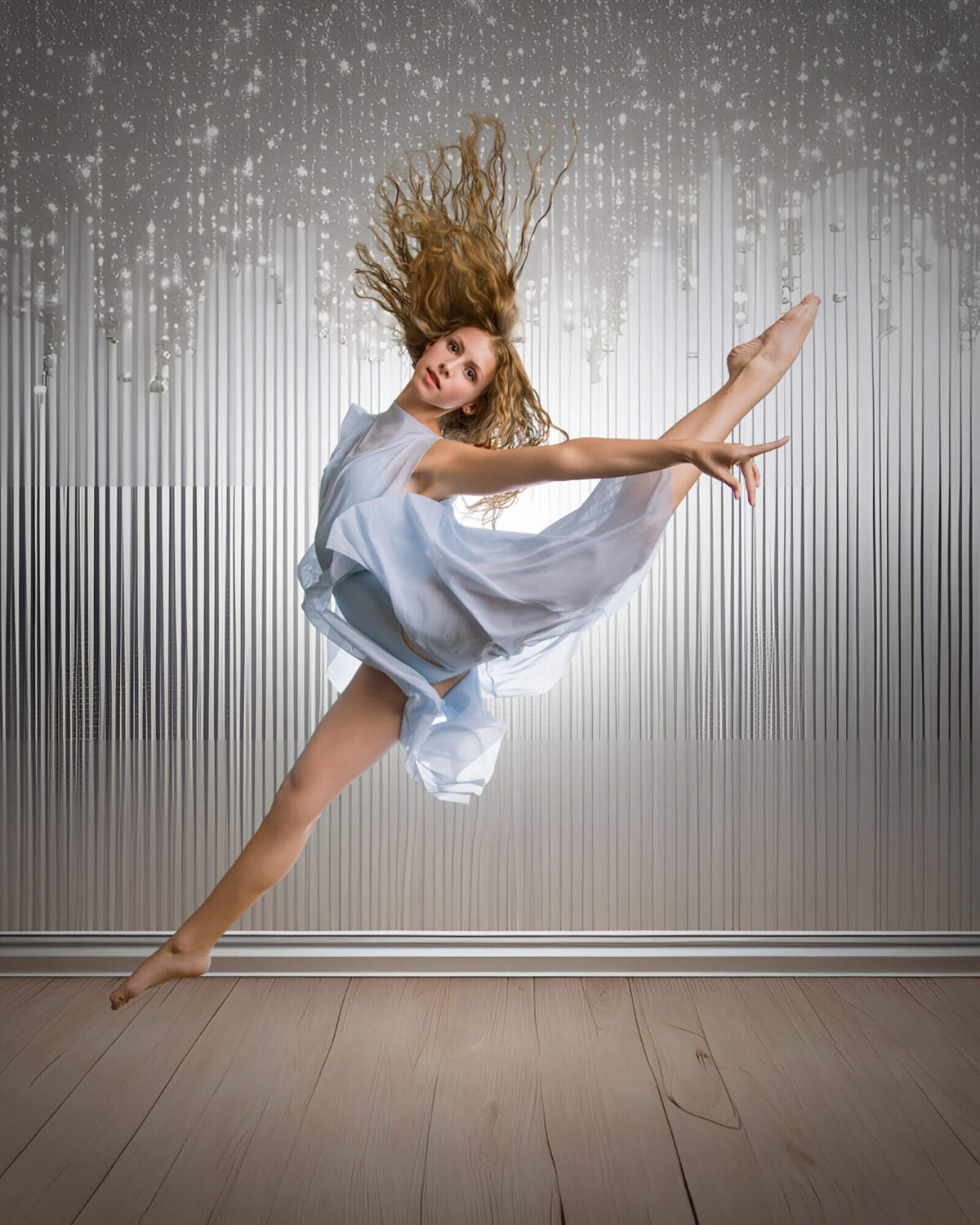 Blonde dancer in a light blue leotard in a stunning firebird leap taken by las vegas dance photographer