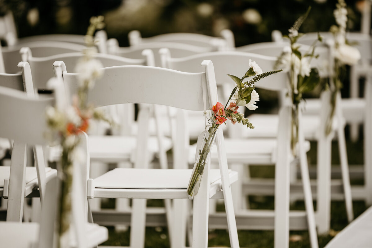 Elegant opgestelde stoelen met bloemendecoraties langs het gangpad, klaar voor een romantische trouwceremonie.