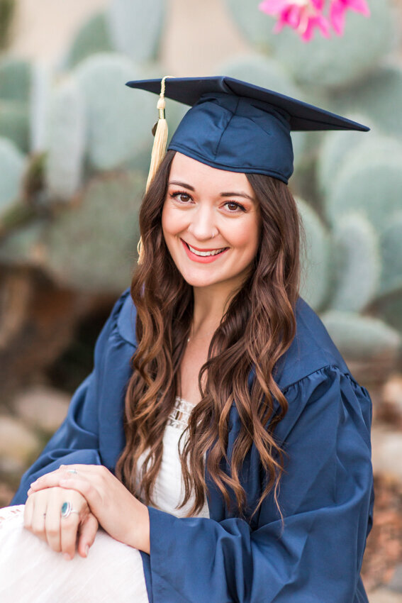 senior girl with cap and gown sitting