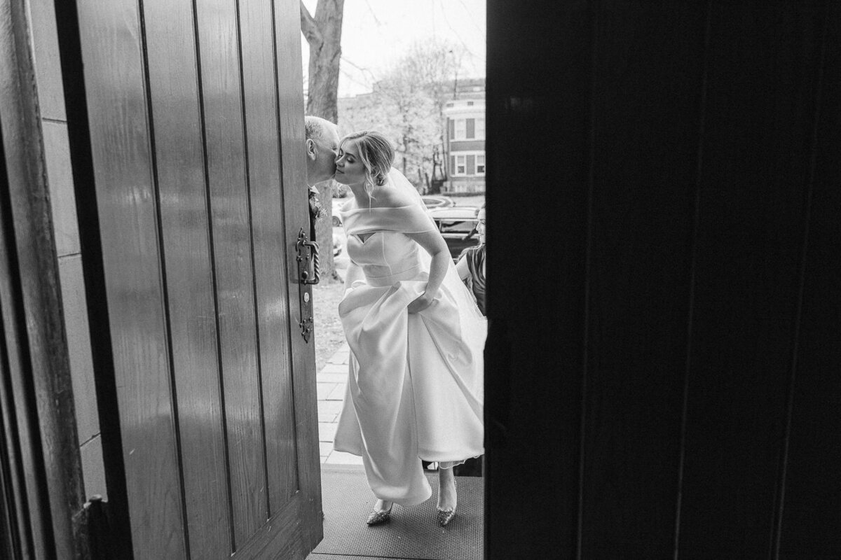 Le père de la mariée embrasse sa fille à son arrivée à l'église pour la cérémonie de mariage.