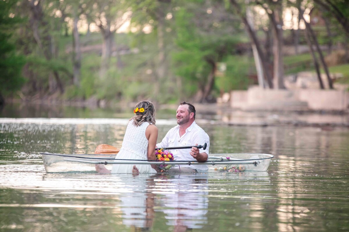 rowing clear canoe at River Road Escapes by New Braunfels wedding photographer Firefly Photography
