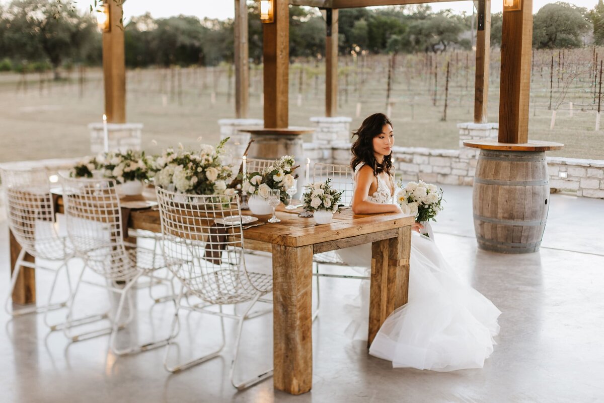 bride sitting at decorative table in pavillion