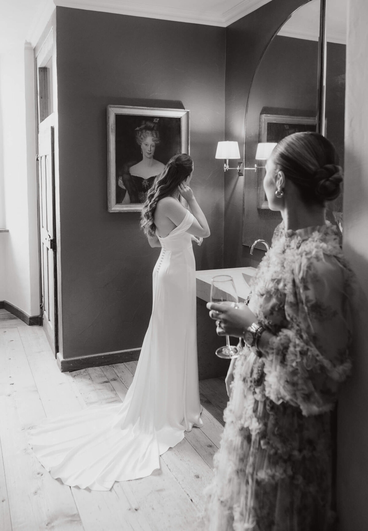 Braut wird beim Anziehen unterstützt – liebevolle Vorbereitung im Palast Hohenems.

