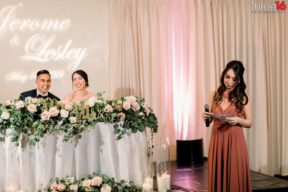 Bride and Groom laugh at a toast by the Maid of Honor