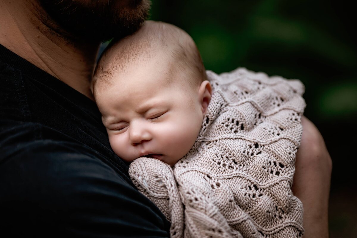 Baby girl asleep in her father's arms