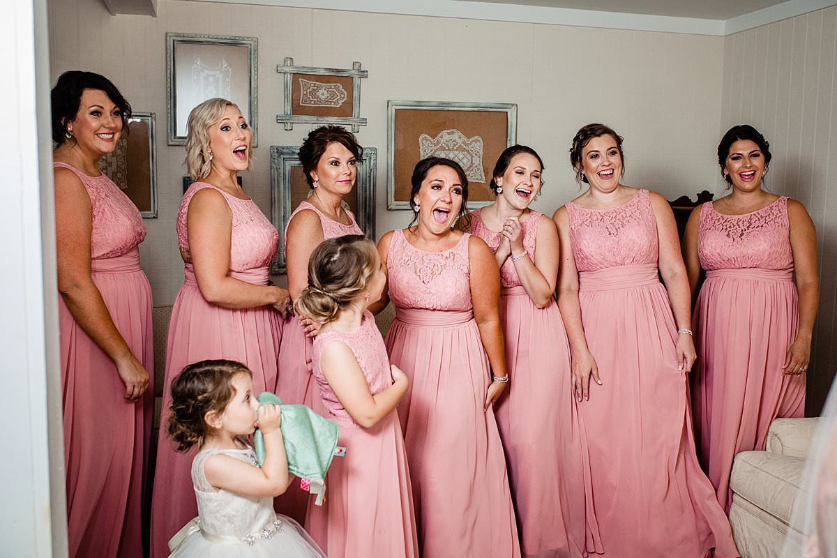 Bridesmaids seeing bride in her wedding dress for the first time