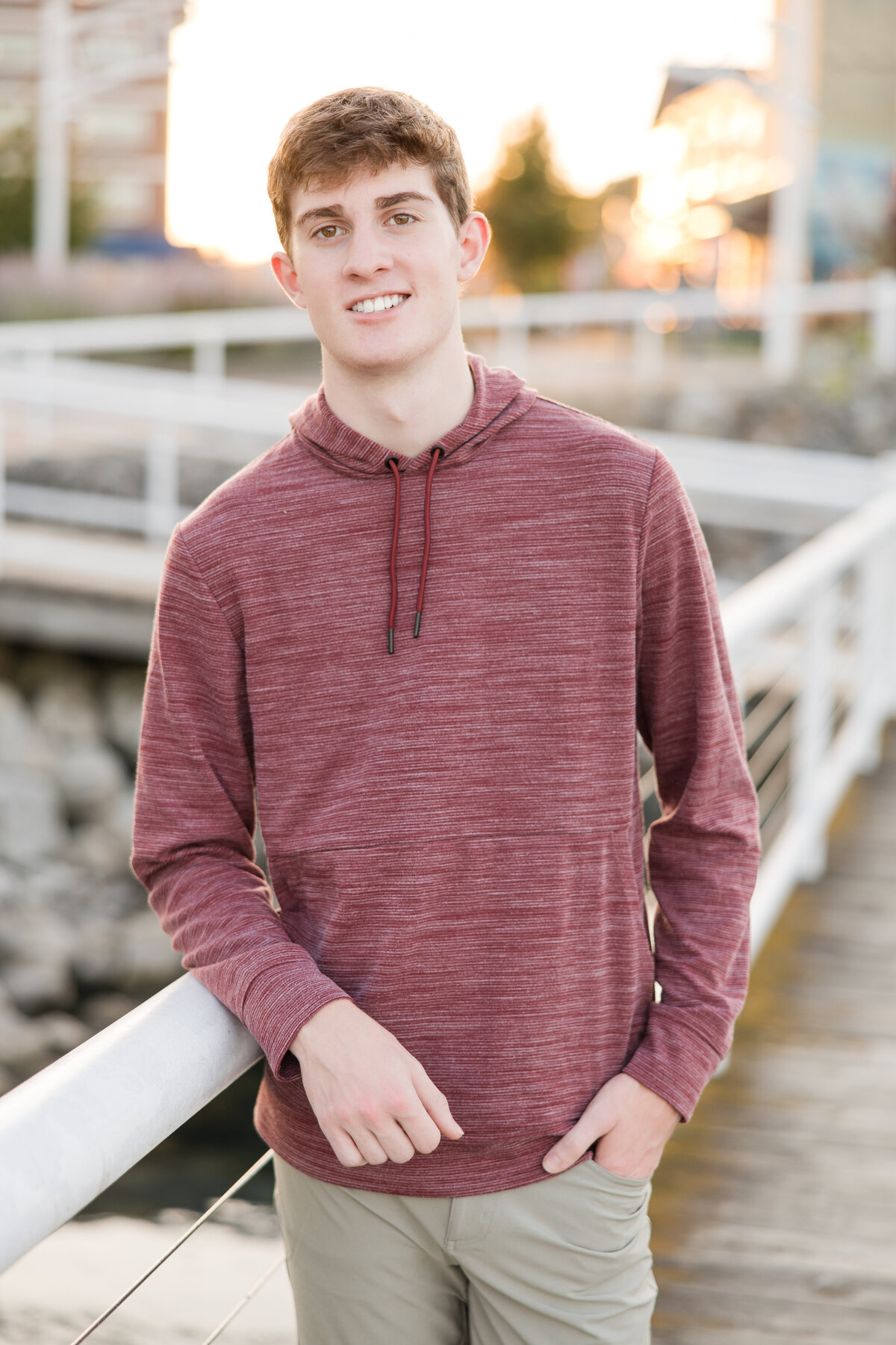 Senior guy leaning against a rail, smiling at the camera