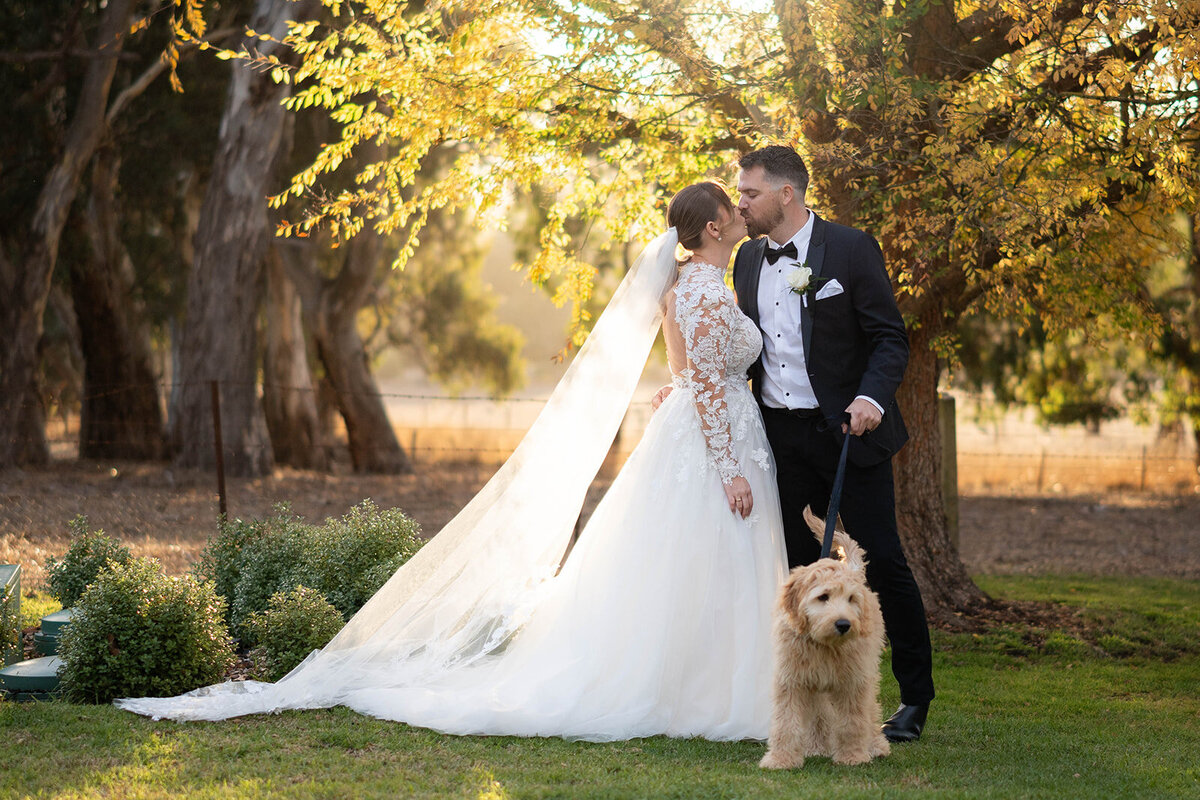 The couple posing for a photo with their dog