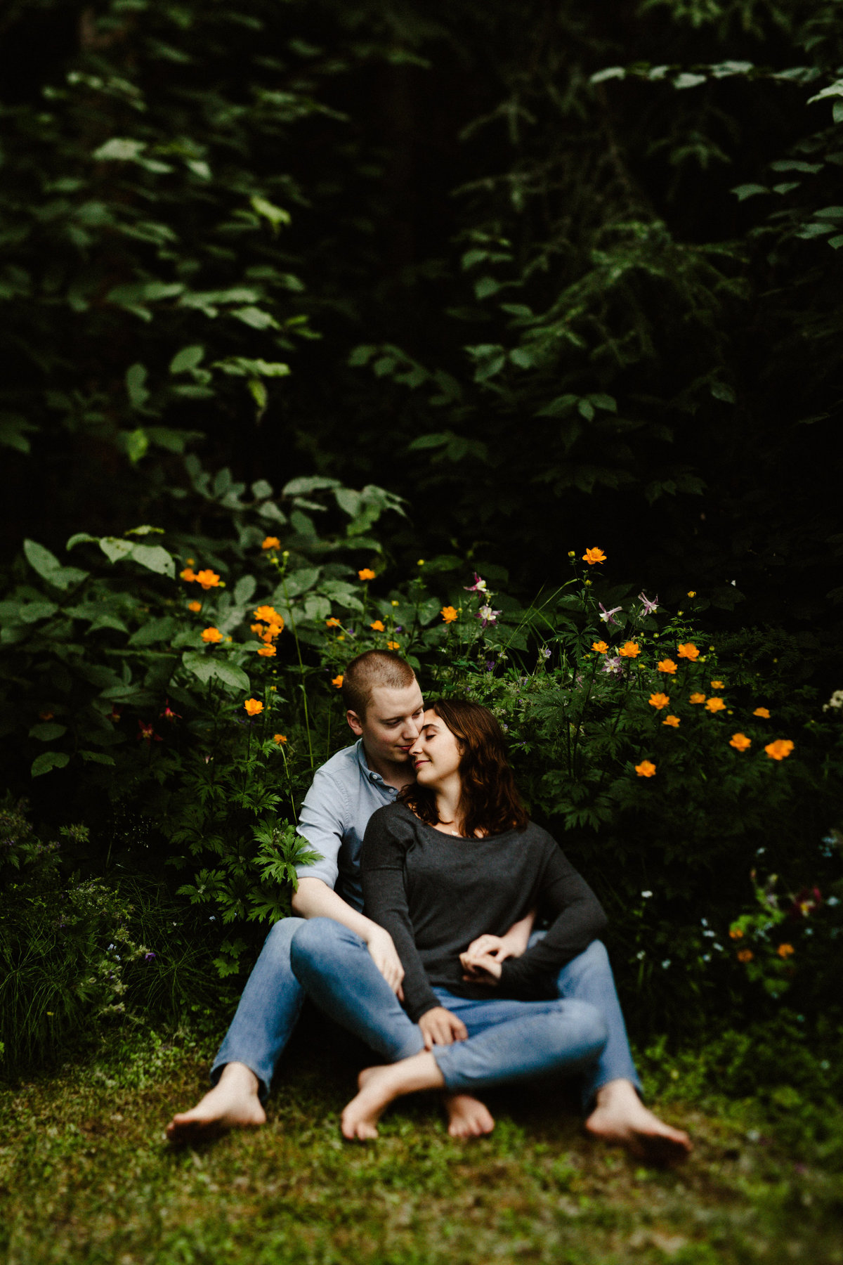 couple sits in garden surrounded by orange wildflowers