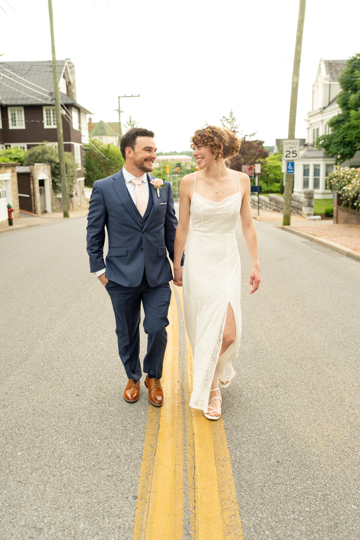 Bride and groom walking in street.