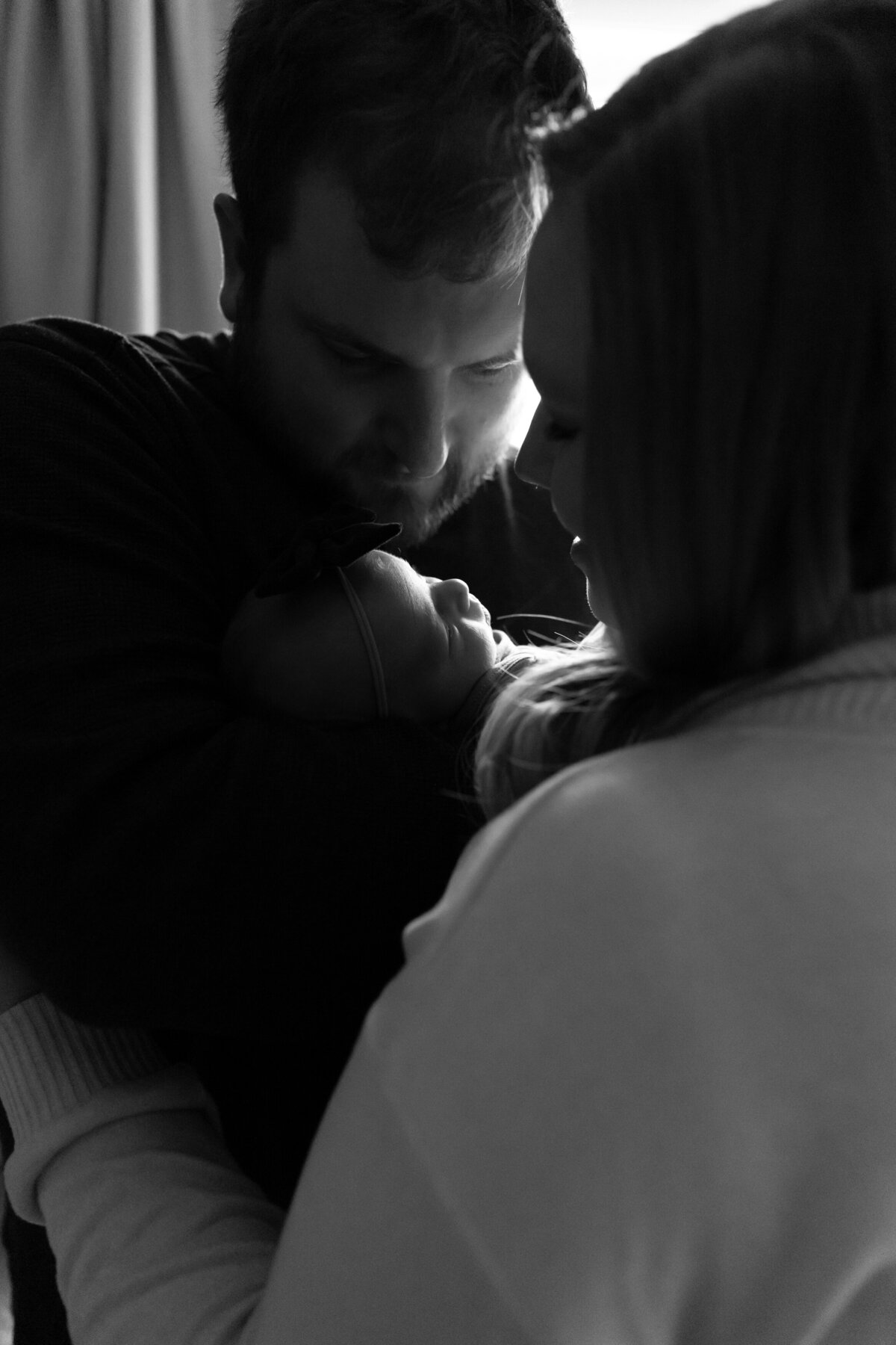 black-and-white-mom-dad-newborn-baby-window
