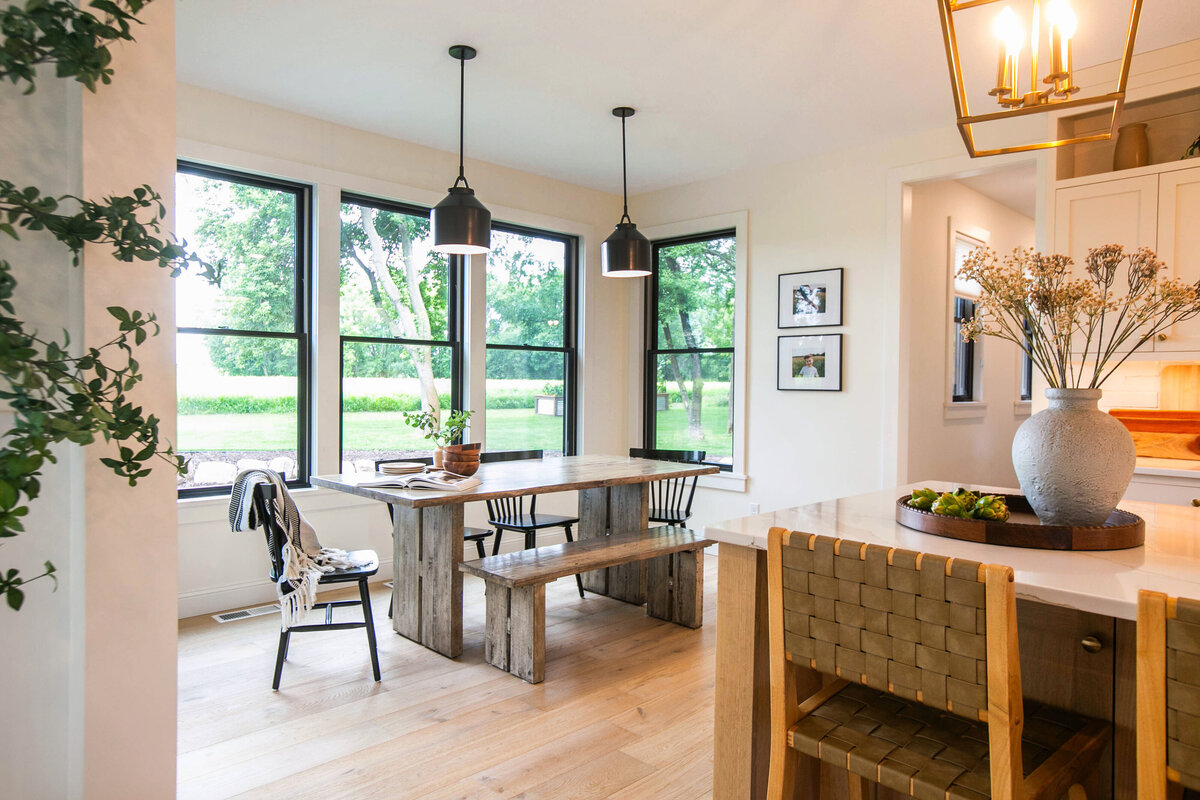 Open kitchen with eat in dining area, white cabinets, large island, and quartz countertops in an Otsego custom home
