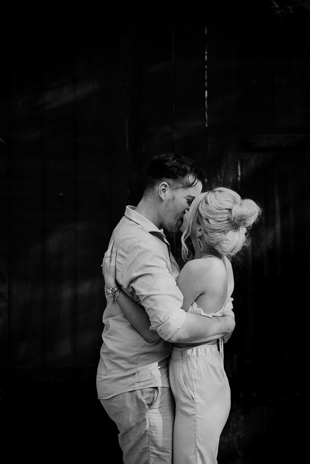 Couple in bright cloth kissing with black background