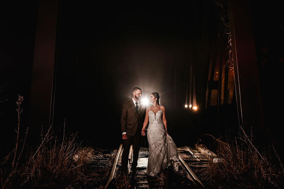 Bride and groom walking on train tracks at Common Man Inn wedding in Plymouth NH by Lisa Smith Photography