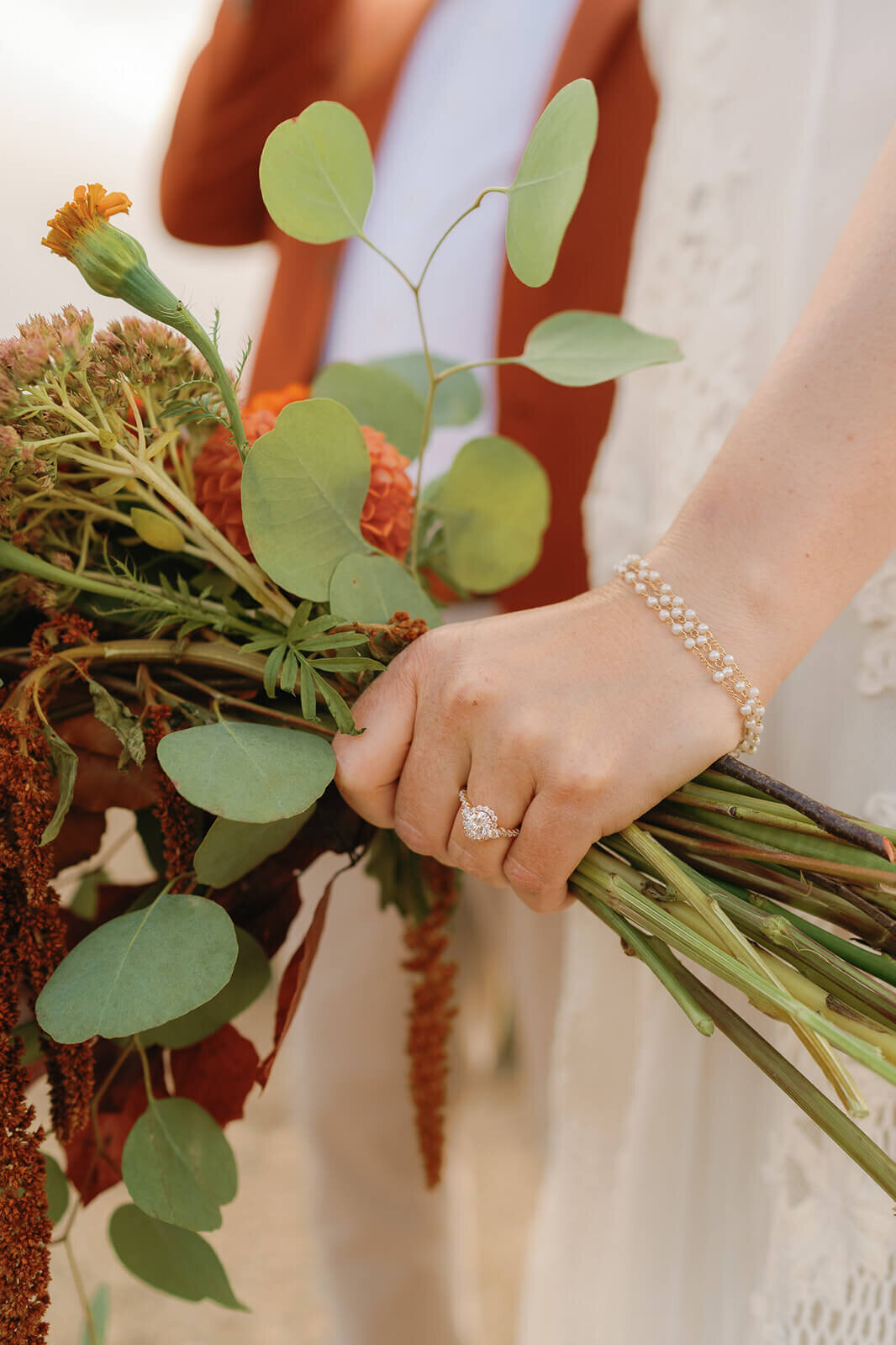 brides ring hand holding her flowers