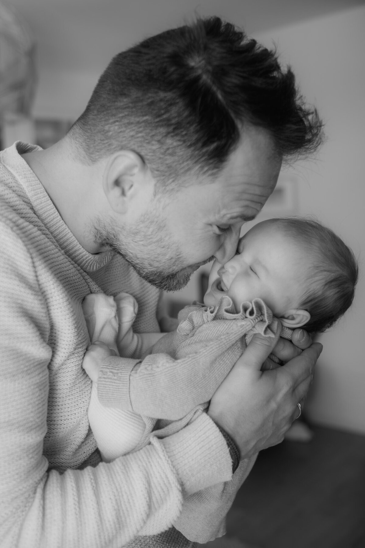 Special moment of dad kissing the newborn, who is laughing
