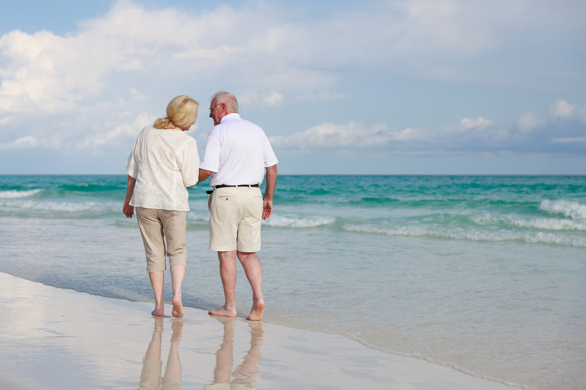50th anniversary photo of grandparents on the beach in front of The Inn at Crystal Beach in Destin, FLorida.